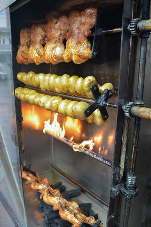 roasted chicken on the spit in the open air in the restaurantの写真素材