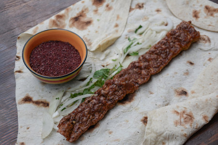 Turkish kebab with onion and pita bread on wooden tableの写真素材