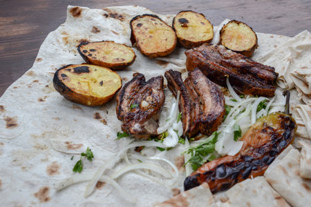 Grilled meat with potatoes and onion on a pita bread.の写真素材