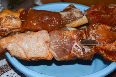 Skewers of lamb on a blue plate on the tableの写真素材