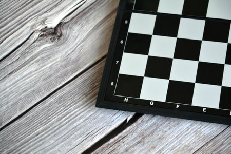 Chess board on wooden background, top view. Space for text