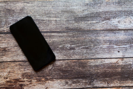 Black smartphone on a wooden table.の写真素材