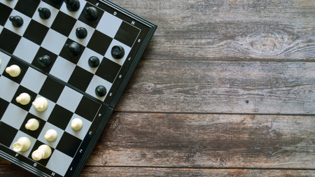 Chess board with black and white chess pieces on wooden background.の写真素材