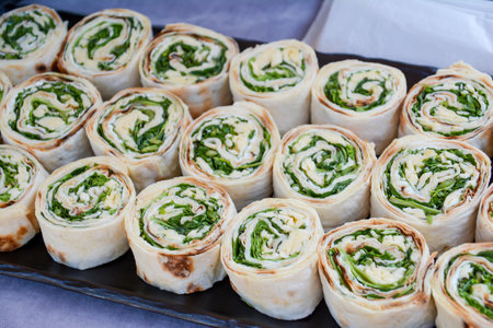 Rolls of cheese and spinach on a tray at a street food marketの写真素材