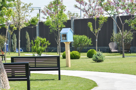 Birdhouse in the park with green grass and trees in the backgroundの写真素材