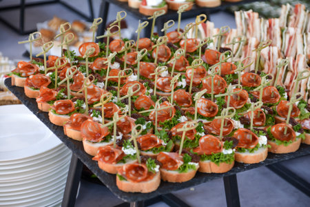 Canapes with cheese and salami on the table at a buffet