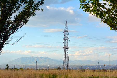High voltage pylons in the field with blue sky background.の写真素材