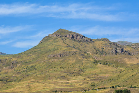 Mountain landscape with green grass, blue sky and white clouds.の写真素材