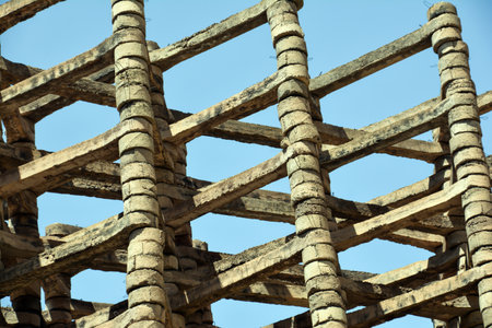 Old wooden scaffolding with blue sky as background, closeup of photoの写真素材