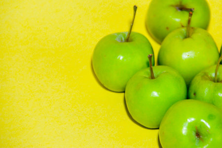Green apples on a yellow background. Green apples on a yellow background.の写真素材