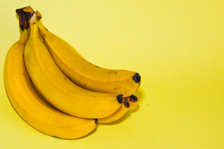Bunch of bananas on a yellow background. The concept of healthy eating.