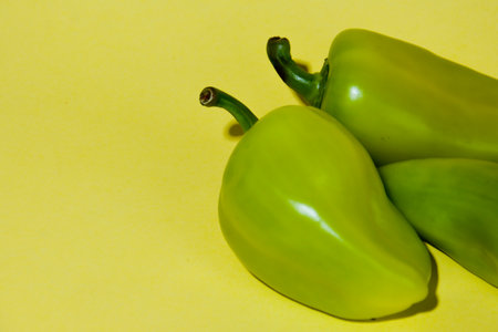 Green peppers on a yellow background. Vegetables on a yellow background.の写真素材
