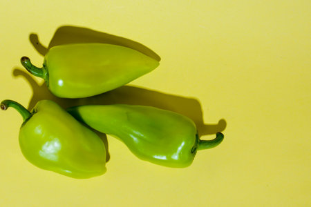 Green peppers on a yellow background. Vegetables on a yellow background.の写真素材