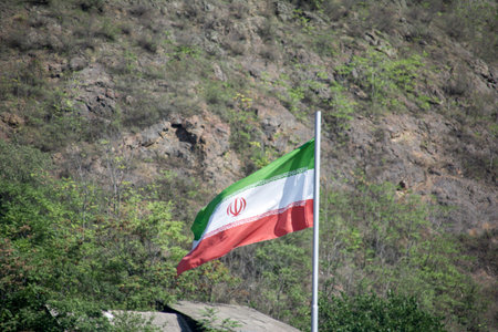 The national flag of the Republic of Iran on a flagpole.の写真素材