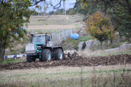 Tractor plowing the field in a rural area in autumn.