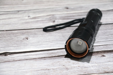 Black flashlight on a wooden background. A flashlight on a wooden background.の写真素材