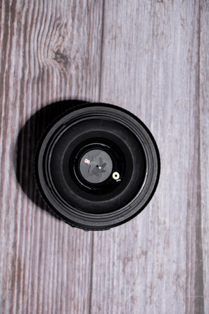 Camera lens on a wooden background. Top view. Copy space.