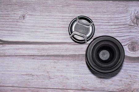 Camera lens on a wooden background. Top view. Copy space.