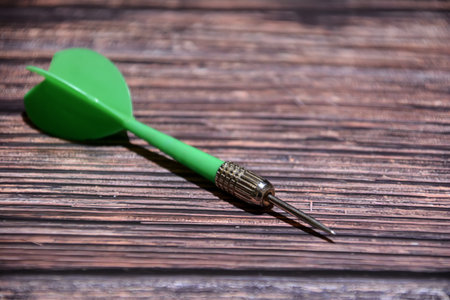 Green dart on a wooden background. The concept of business success.の写真素材