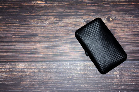 Black wallet on a wooden background. Top view. Copy space.の写真素材