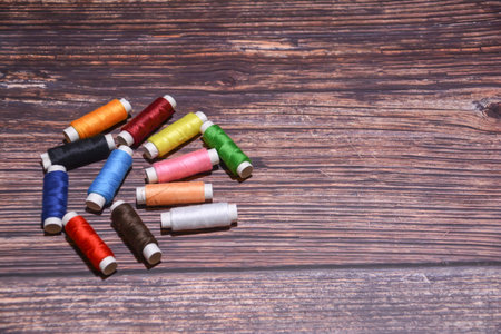 Colorful sewing threads on wooden background. Copy space for text.の写真素材