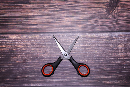 Scissors on a wooden background, top view, copy space.の写真素材