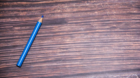 Blue pencil on the wooden background with copy space for your text.の写真素材