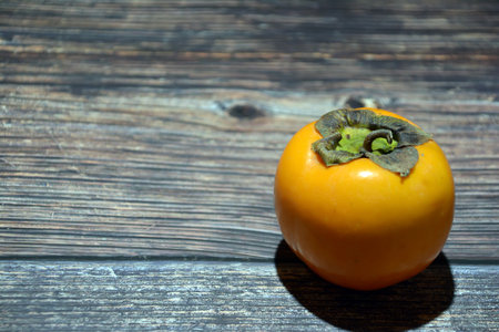 Ripe persimmon fruit on a wooden background. Selective focus.の写真素材