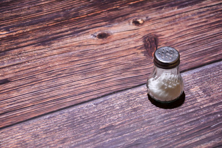 Salt and pepper shaker on wooden background. Shallow dof.
