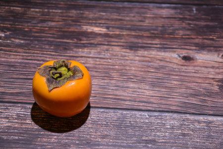 Fresh persimmon fruit on wooden background. Selective focus.の写真素材