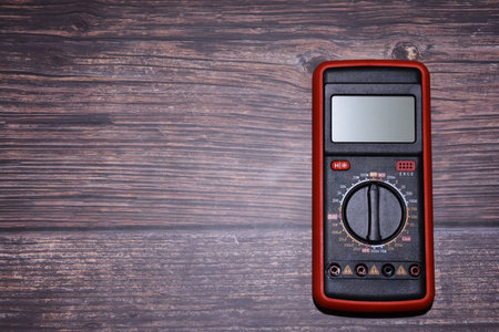 Digital multimeter on dark wooden background with copy space for text.の写真素材