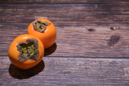 Persimmon fruit on wooden background. Copy space for text.の写真素材