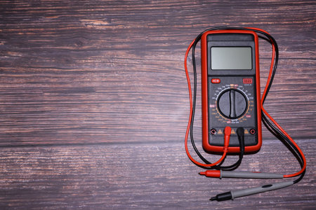 Digital multimeter on a dark wooden background. Electrician equipment.の写真素材