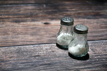 Salt and pepper shakers on wooden background. Selective focus.の写真素材