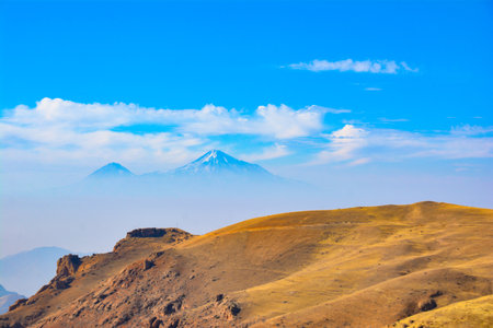Mountain in the clouds. Beautiful mountain. Beautiful natural landscape with fields and mountains. Cloudy sky and mountain peakの写真素材