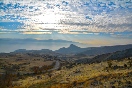 Mountain in the clouds. Beautiful mountain. Beautiful natural landscape with fields and mountains. Cloudy sky and mountain peakの写真素材