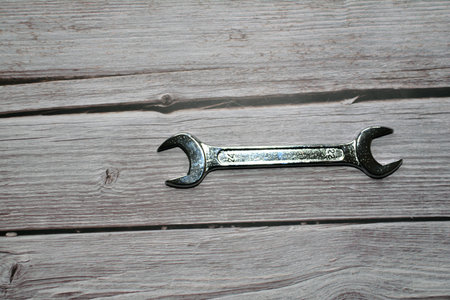Wrench on a wooden background, close-up, top view