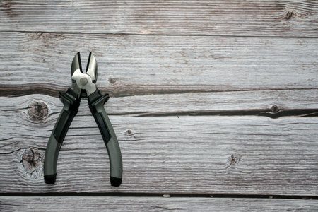 Pliers on a wooden background. Pliers and nipper on the table. Pliers with plastic handle. Tools for master. Work tool.