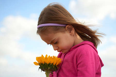 Portrait of little girl watching some sunflowers