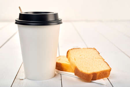 Coffee cup with pound cake on a wooden tableの写真素材