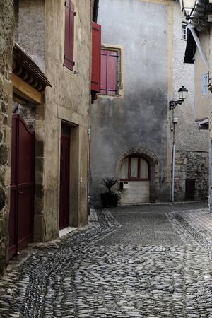 Rustique street in Beaulieu-sur-Dordogne with red doors and shutters.のeditorial素材