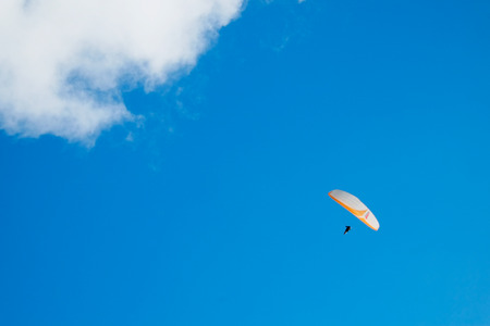 Paragliding over blue sky with small cloud