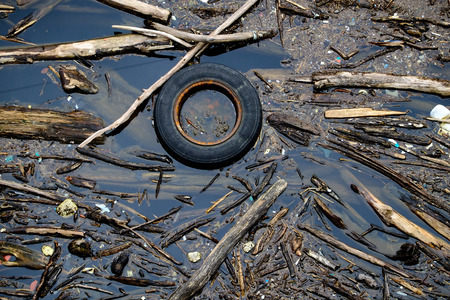 Water pollution with a tire and driftwood.の写真素材