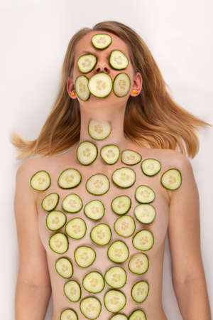 A young woman with a cucumber face maskの写真素材