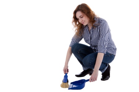 A young woman is sweeping up dirt with a hand brushの写真素材