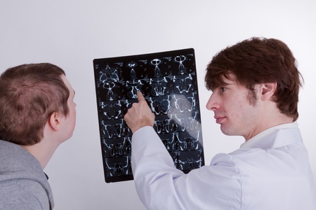 A doctor explains a young man his lungs problemsの写真素材