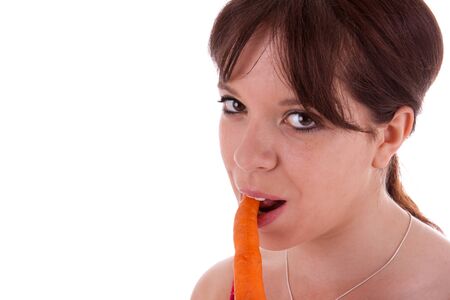The pretty young woman biting into a carrotの写真素材