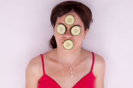 The pretty young woman with a cucumber maskの写真素材