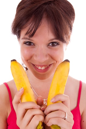 The pretty young woman has two bananas in her handの写真素材