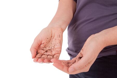 A young woman with dirty hands is standing in front of a cameraの写真素材
